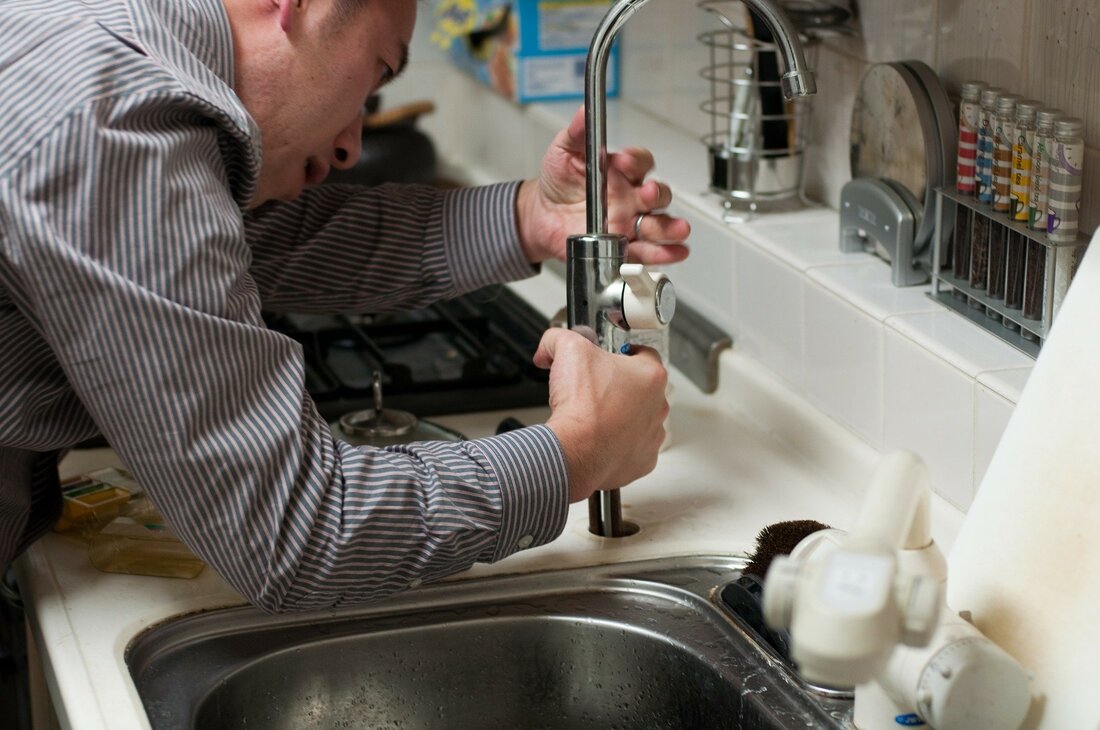 A home inspector in Akron Ohio looks at the kitchen faucet in a home he is inspecting.
